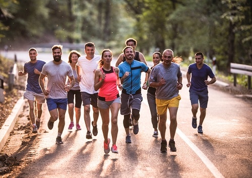 Large group of athletic people running a marathon on the road