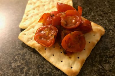 Tomato bruschetta topping on a cracker