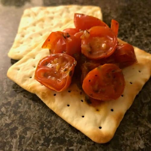 Tomato bruschetta topping on a cracker