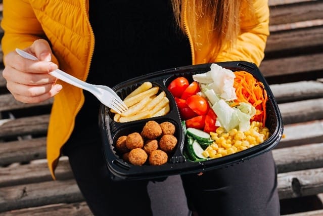 man holding to-go container of food